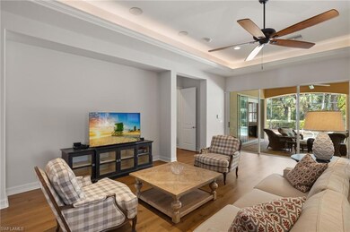 Living room featuring a tray ceiling, light hardwo