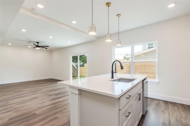 Kitchen with a sink, dark wood finished floors, b