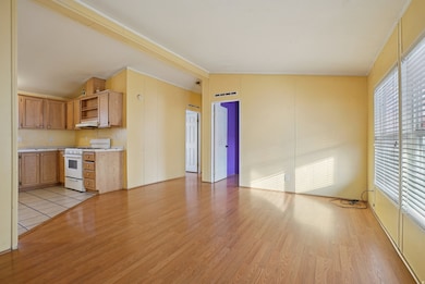 Kitchen with open shelves, white gas range oven, light countertops, light wood-type flooring, and lofted ceiling
