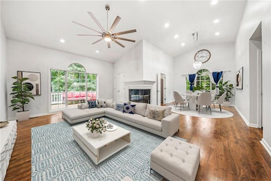 Virtually Staged Living Room with Vaulted Ceilings, Recessed Lighting, Ceiling Fan, Glass-Covered Fireplace, and Wood-Finished Floors