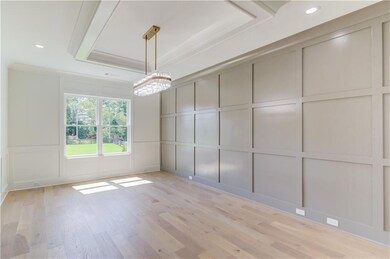 Unfurnished room featuring a chandelier, a tray ceiling, and light wood-type flooring