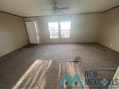 Carpeted spare room with a ceiling fan and ornamental molding