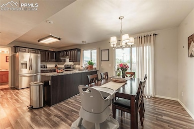 Dining area featuring sink, a chandelier, and wood