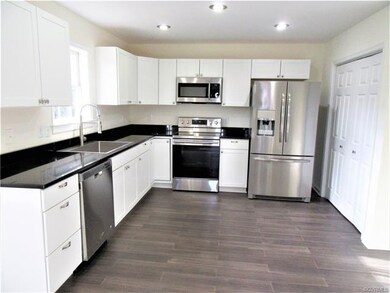 Eat-in Kitchen boasts Bamboo Flooring, Neutral Paint Palette, Recessed Lighting, White Shaker-Style Cabinetry with Brushed Nickel Knobs & Hidden Hinges, and Gorgeous Granite Countertops!