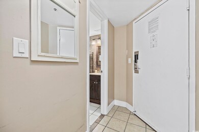 Hallway with light tile patterned flooring and bas