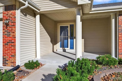 Doorway to property featuring brick siding and covered porch