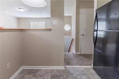 Hallway with baseboards and a textured ceiling