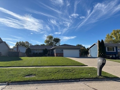 Ranch-style house with concrete driveway, a garage, and brick siding
