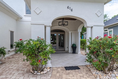 View of exterior entry featuring french doors and stucco siding