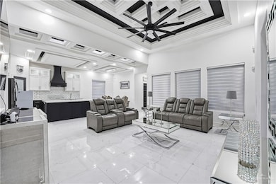 Living room with coffered ceiling, recessed lighting, and ceiling fan