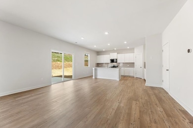 Unfurnished living room with recessed lighting, light wood-type flooring, and baseboards