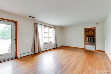 Unfurnished living room featuring baseboard heatin