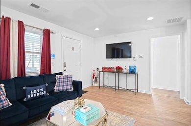 Living room featuring wood finished floors, baseboards, and recessed lighting