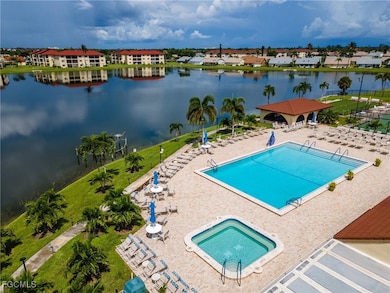Community pool featuring a water view, a patio, and a yard