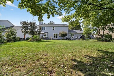 Back of property with a yard, a chimney, and a patio