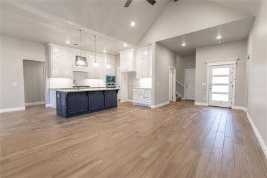 Kitchen with white cabinetry, hanging light fixtur