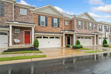 View of property with an attached garage, driveway, and brick siding