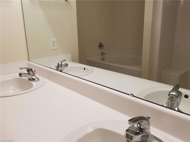 Double sinks and a reflection in the mirror of the garden tub and shower
