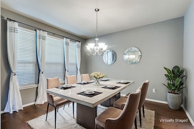 Dining room featuring dark wood-style flooring and a chandelier