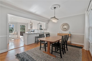 Dining area with a chandelier, crown molding, ligh
