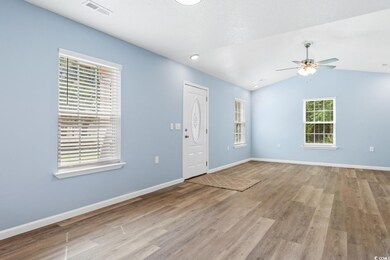 Spare room with ceiling fan, vaulted ceiling, and 