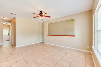 Empty room with a ceiling fan and light tile patte