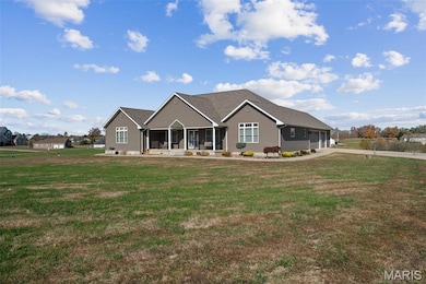 View of front and side of house featuring a porch, a garage, a front yard, and concrete driveway