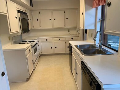 Kitchen with light tile floors, white range with e