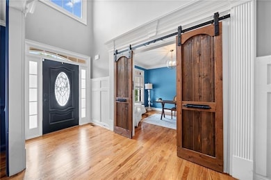 Foyer with a high ceiling, a barn door, and light 