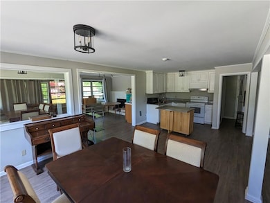 Dining space featuring crown molding, dark hardwoo