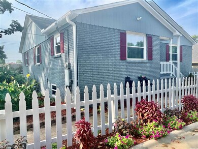 Flowers & plants line front & behind picket fence