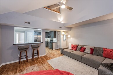 Hardwood floored living room featuring ceiling fan