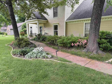 View of front of house featuring a shingled roof and a front lawn