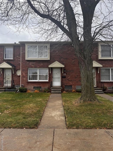 View of front facade with entry steps, a front lawn, and brick siding