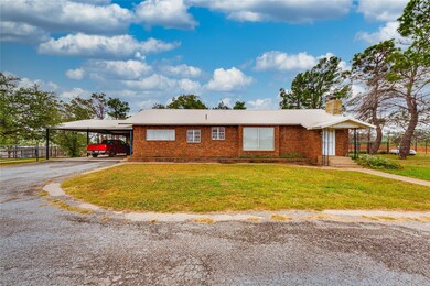 Single story home with brick siding, aphalt drivew