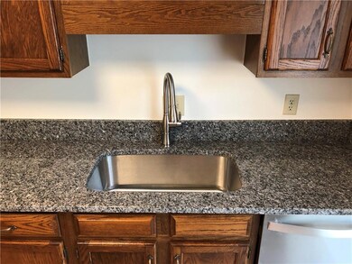Kitchen view of dishwasher and dark stone countertops