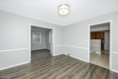 Empty room with dark wood-type flooring