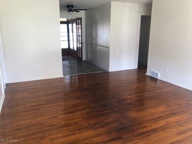Living room with ceiling fan and dark wood-type flooring