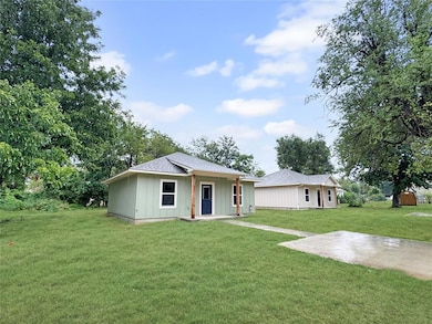 Front view of the home featuring a covered entry, neutral exterior, and spacious front yard. Note: Photos are of a similar home by the builder.