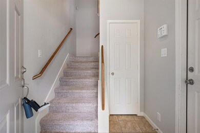 Stairway featuring tile patterned floors and baseboards