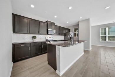 The kitchen has granite countertops with a subway