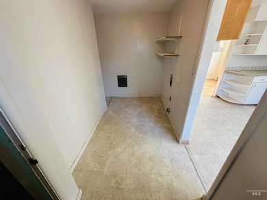 Laundry area with baseboards and light tile patterned floors
