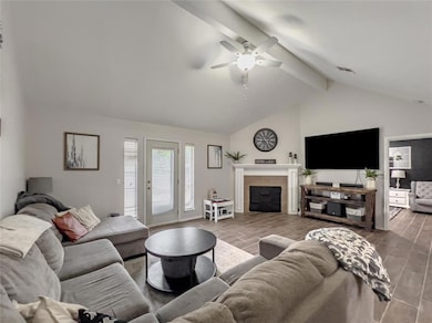 Living area featuring wood finish floors, a fireplace, and a ceiling fan
