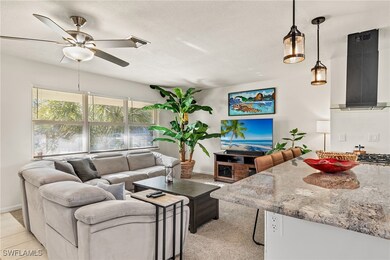 Carpeted living room featuring ceiling fan and a t