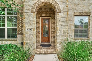 The covered entry has a wood door with wrought iron and glass.
