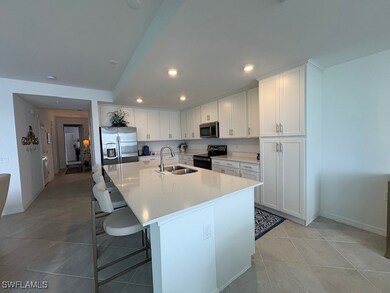 Kitchen has Quartz counters, breakfast bar with stools, stainless steel appliances and recessed lighting.