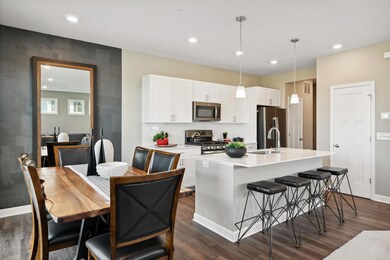 The beautiful kitchen features quartz countertops, white subway tile backsplash & pendant lighting. The island has seating for four! *Photos of model home; colors and finishes will vary.