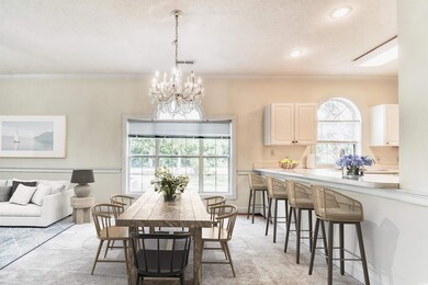 Dining space featuring light carpet, a chandelier,