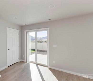 Kitchen featuring stainless steel fridge with ice dispenser, light wood finished floors, hanging light fixtures, a mountain view, and recessed lighting