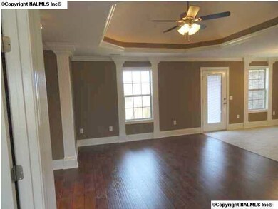 View into living room from the foyer. Trey ceilings with recessed lights and ceiling fan